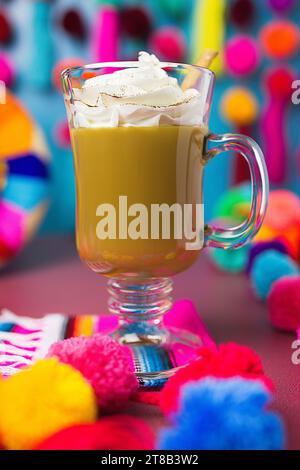 mexikanischer Kaffee in einem Glasbecher mit Schlagsahne und Zimtstab Stockfoto