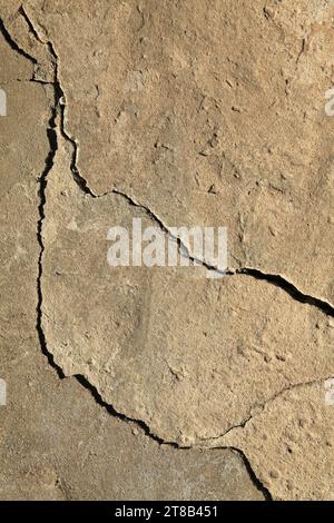 Riss in der Betonverkleidung eines alten Hauses. Raue, unebene Oberfläche. Zementputz an einer Ziegelwand, Textur, Hintergrund. Antike Kulisse Stockfoto