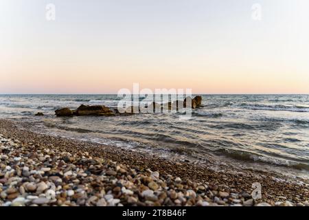 Steine im Meer am Kourion Strand in Episkopi, Zypern Stockfoto