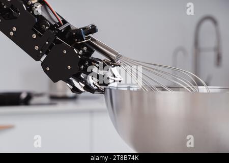 Echte Roboterhand und Schneebesen aus Edelstahl. Konzept der Roboterprozessautomatisierung. Stockfoto