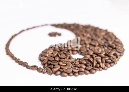 yin Yang-Schild von Kaffeebohnen auf weißem Hintergrund Stockfoto