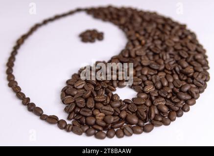 yin Yang-Schild von Kaffeebohnen auf weißem Hintergrund Stockfoto