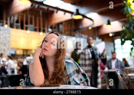 Langweiliges Mädchen, das im Coffee Shop auf ihr Date wartet. Eine Frau stand auf, die eine schlechte Zeit allein im Restaurant hatte Stockfoto