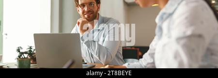 Zwei verschiedene Geschäftskollegen arbeiten gemeinsam an einem Projekt und sitzen in einem modernen Tagungsraum Stockfoto