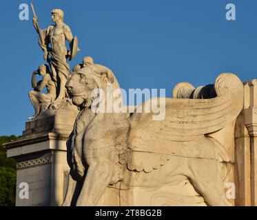 Mit Marmor geflügelter Löwe, Teil des Victor Emmanuel Monuments steht neben der Skulptur „Helden auf der Piazza Venezia“. Rom, Italien, Europa. Stockfoto