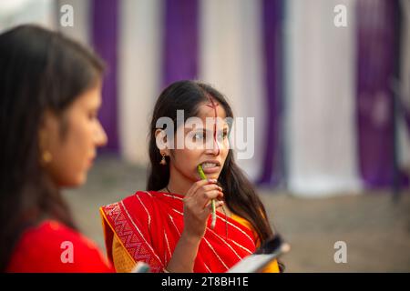Eine Devotee putzt sich die Zähne mit einem Neemstäbchen während eines Rituals am Ufer des Yamuna-Flusses bei Kalindi Kunj Barrage anlässlich des Chhath Puja in Noida. Chhath Puja ist ein hinduistisches Festival, das der Anbetung des Sonnengottes gewidmet ist und hauptsächlich in den indischen bundesstaaten Bihar, Jharkhand, Ost-Uttar Pradesh und einigen Teilen Nepals stattfindet. Sechs Tage nach Diwali gefeiert, umfasst es Rituale wie Fasten, heiliges Baden, langes Stehen im Wasser und Gebete für den Untergang und die aufgehende Sonne. Die Gläubigen suchen nach Segnungen für das Wohlergehen und den Wohlstand ihrer Familien. Das festi Stockfoto