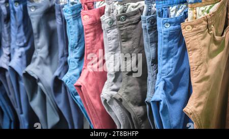 Viele Jeans, die an der Spielbank hängen. Eine Reihe Hosen Jeans, die im Schrank hängen, Konzept des Kaufs, Verkaufs, Einkaufs und Jeans Mode Stockfoto