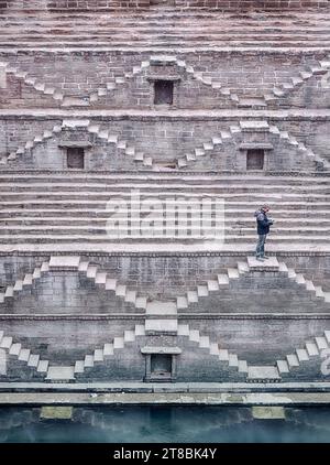 JODHPUR, INDIEN - 31. DEZEMBER 2022: Ein nicht identifizierter Mann steht auf einer Stufe tief im Treppenhaus des Toorji Ka Jhalra Bavdi, der sich im C befindet Stockfoto