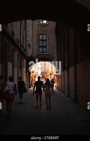 Ein paar spazieren unter einem Bogen in Lyon, Frankreich. Stockfoto