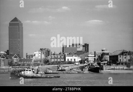 Schwarzweiß-Blick über die Themse aus der Nähe von Greenwich aus dem Archiv der 1990er Jahre. Das Boot auf der Slipway befindet sich am Ende der Ferry Street. Canary Wharf Büroentwicklung links. Stockfoto