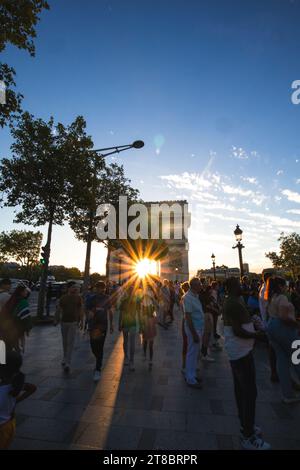 Die Sonne blickt hinter dem Arc de Triomphe in Paris, Frankreich. Stockfoto