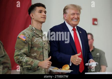 Edinburg, Texas, USA. November 2023. Der ehemalige Präsident DONALD TRUMP posiert am 19. November 2023 in Edinburg, Texas, für ein Foto mit einem Servicemitarbeiter auf dem South Texas International Airport. Trump und der Gouverneur von Texas, GREG ABBOTT, servierten Mahlzeiten an den Texas National Guard und Texas DPS Troopers, die während des Erntedankfestes an der Grenze zwischen den USA und Mexiko stationiert sind. Quelle: ZUMA Press, Inc./Alamy Live News Stockfoto