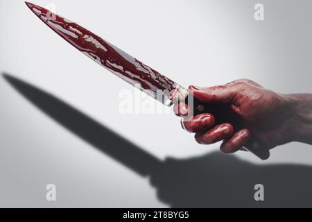 Männliche Hand mit einem Messer in Blutflecken, der Schatten auf weißem Hintergrund wirft Stockfoto