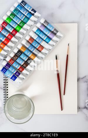 Aquarellfarben Set, Papier, Pinsel, Bleistifte in Nahaufnahme auf einem Tisch, flache Lagen Stockfoto