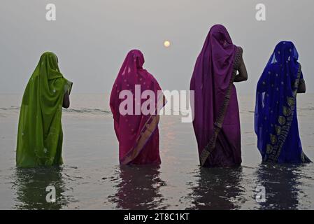 Mumbai, Indien. November 2023. Hindufrauen stehen im Wasser, um zur untergehenden Sonne zu beten anlässlich von Chhath Puja am Strand in Mumbai. Chhath Puja wird von den Menschen aus den nordstaaten Indiens gefeiert. Die Gläubigen versammeln sich in der Nähe eines Wasserkörpers, führen Rituale durch und beten zur untergehenden Sonne am Abend und zur aufgehenden Sonne. Am nächsten Morgen danken sie ihm für das Leben auf der Erde. (Foto: Ashish Vaishnav/SOPA Images/SIPA USA) Credit: SIPA USA/Alamy Live News Stockfoto