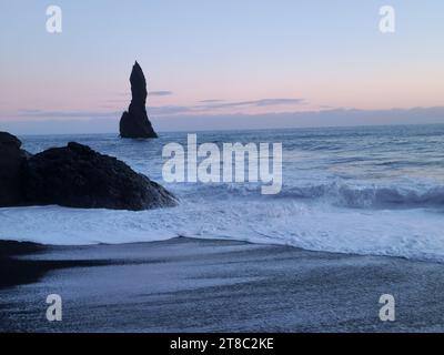 Herrlicher einzigartiger Strand von reynisfjara mit Basalt-Felsformationen und rosa Himmel bei Sonnenuntergang, schwarzer Sandstrand in der Nähe des Reynisfjall Berges. Isländische Landschaft der atlantikküste, nordische Natur. Stockfoto