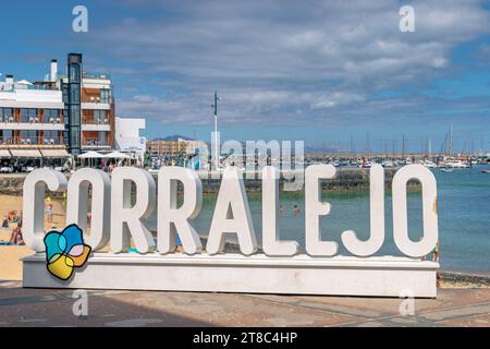 Corralejo, Spanien. 25. September 2023: Blick auf das Corralejo-Schild am alten Hafenstrand Corralejo, Fuerteventura mit dem neuen Hafen und Yatchen in Stockfoto