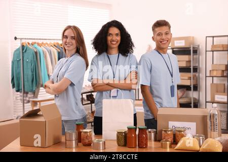 Porträt von Freiwilligen und Lebensmitteln am Tisch im Lager Stockfoto