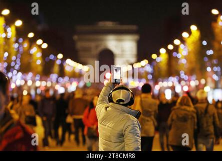 Paris, Frankreich. November 2023. Eine Person macht ein Foto von der Champs-Elysees Avenue beleuchtet von Weihnachtsbeleuchtung in Paris, Frankreich, 19. November 2023. Die jährliche Weihnachtsfeier fand hier am Sonntag statt. Quelle: Gao Jing/Xinhua/Alamy Live News Stockfoto