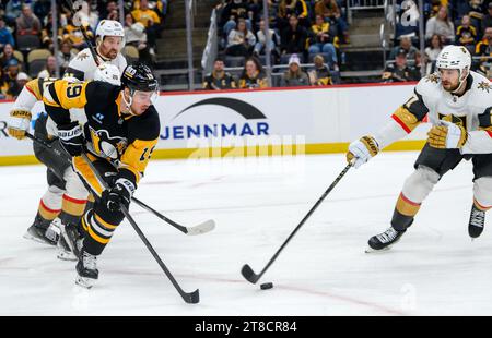 Pittsburgh, Usa. November 2023. Der rechte Flügel der Pittsburgh Penguins Reilly Smith (19) rennt auf den Puck zu, als der Verteidiger Shea Theodore (27) von Vegas Golden Knights ihn während der dritten Periode in der PPG Paints Arena in Pittsburgh am Sonntag, den 19. November 2023 abklopft. Foto von Archie Carpenter/UPI. Quelle: UPI/Alamy Live News Stockfoto