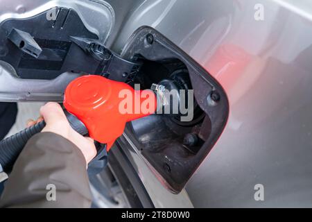 Mann pumpt Benzin in das Auto an der Tankstelle. Stockfoto