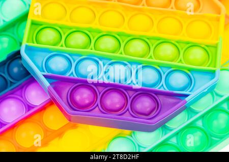 Mach es aus der Nahaufnahme mit Anti-Stress. Modernes Antistress-Spielzeug. Hintergrund von Regenbogenspielzeugen. Stockfoto