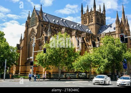 Sydney, New South Wales, Australien - 11. Oktober 2022: Autos und Fußgänger kommen an einem sonnigen Frühlingstag an der St Mary’s Cathedral vorbei Stockfoto