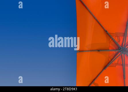 Urlaubs- oder Urlaubskonzept mit Kopierraum, flacher Blick auf den orangen Strand oder Sonnenschirm am Pool. Stockfoto