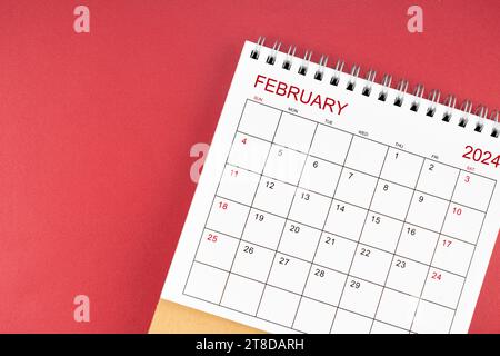Schreibtischkalender Februar 2024 auf rotem Hintergrund. Stockfoto