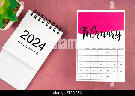 Kalenderseite Februar 2024 mit Pflanztopf auf rotem Hintergrund. Stockfoto