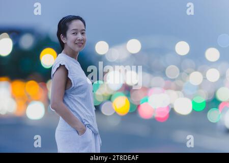 Porträt einer asiatischen Frau mit Happy Smile und Bokeh-Licht im Hintergrund. Stockfoto