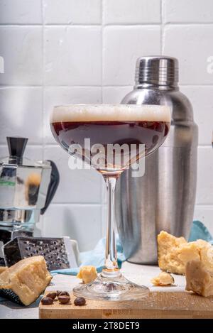 Parmesan Cheese Espresso Martini Cocktail, käsiges Schlagsahne Kaffeegetränk in martini Glas mit geriebenem Parmesan Stockfoto