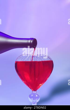 Rotwein in herzförmiges Glas gießen - romantisches Dinner aus der Nähe mit violetten und roten Tönen Stockfoto