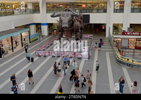 Leute warten auf Züge neben Ozzy the Bull am New Street Railway Station, Birmingham, August 2023 Stockfoto