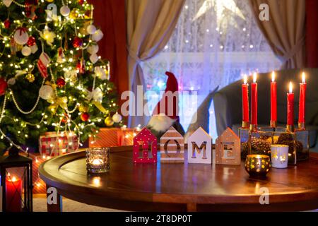 Weihnachtsbaumschmuck im Wohnzimmer bei Nacht. Weihnachtliche Einrichtung mit Girlanden Kerzen, Geschenke unter dem Weihnachtsbaum, alles ist bereit für Weihnachten. Stockfoto
