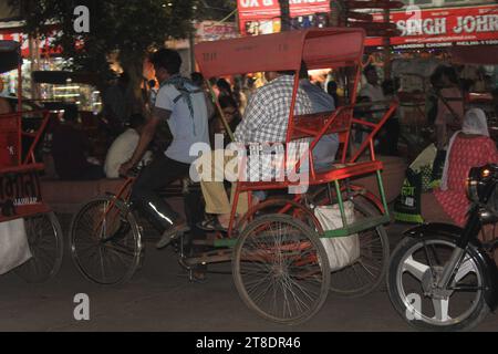 Ein unbekannter Rikscha-Abzieher, der nachts auf den Straßen des Chandni Chowk Markts in Neu-Delhi, Indien, am 14. November 2023 arbeitete. Stockfoto