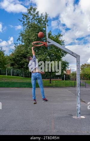 Ivry-Sur-seine, Frankreich - 10 04 2021: Ein junger Mann spielt Basketball und springt, um einen Korb zu schießen Stockfoto