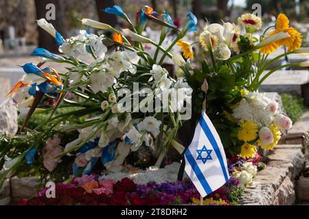 Eine Flagge des Staates Israel ruht auf einem Grab eines gefallenen Soldaten, bedeckt mit bunten Blumen auf dem Har Herzl Militärfriedhof in Jerusalem auf mir Stockfoto