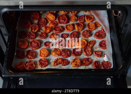 Schalen mit frischen Kirschtomaten auf Gestellen trocknen im Ofen Stockfoto