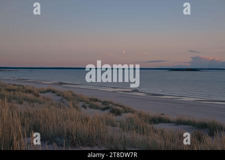 Sanddünen am Meer und der Mond am Himmel Stockfoto