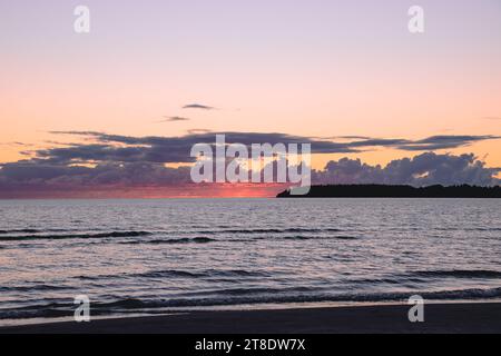 Hellroter Sonnenuntergang an einem bewölkten Himmel vor dem Hintergrund des Meeres Stockfoto