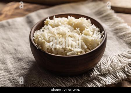 Fermentierter Kohl in einer Schüssel auf hölzernem Schneidebrett. Stockfoto