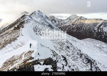 Solo-Wanderer auf einem verschneiten Bergrücken Stockfoto