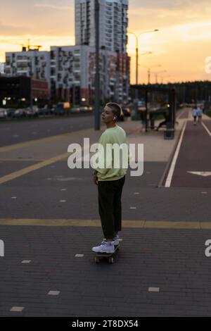 Eine junge Frau fährt auf einem Longboard durch die Straßen der Stadt. Stockfoto