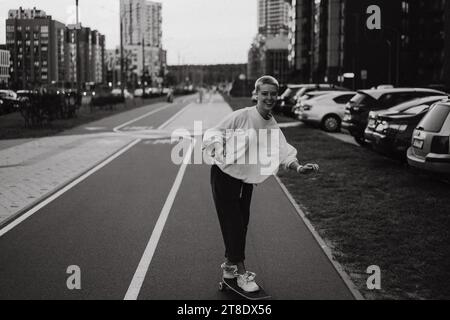 Eine junge Frau fährt auf einem Longboard durch die Straßen der Stadt. Stockfoto