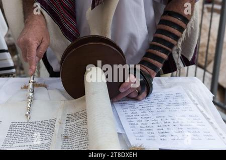 Nahaufnahme einer Hand, die einen yad oder Zeiger hält, um den Leser durch den hebräischen Text der jüdischen Thora zu führen. Stockfoto