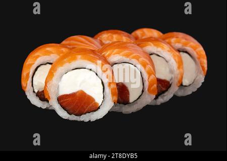 Sushi-Brötchen mit Lachs, Frischkäse auf schwarzem Hintergrund. Sushi-Menü Stockfoto