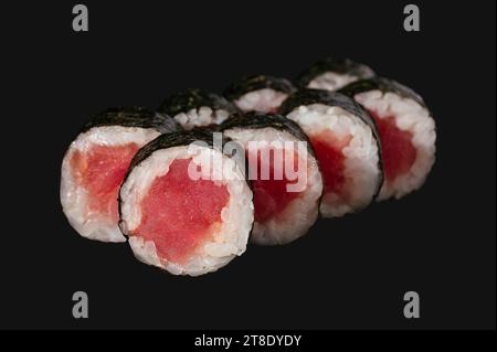 Sushi-Rolle mit Thunfisch isoliert auf schwarzem Hintergrund. Stockfoto