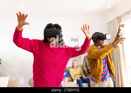 Glückliche Teenager-Freunde, die vr-Headsets verwenden und zu Hause spielen Stockfoto