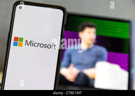 Microsoft-Logo und Sam Altman im Hintergrund auf dem Bildschirm.Microsoft stellt Sam Altman ein Stockfoto